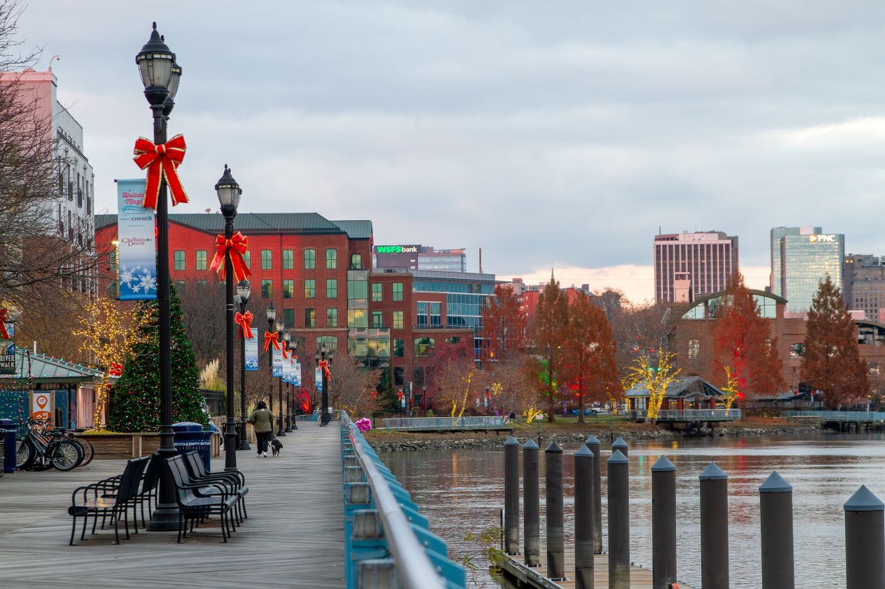 Festively decorated Wilmington riverfront with holiday lights and bows along the walkway.